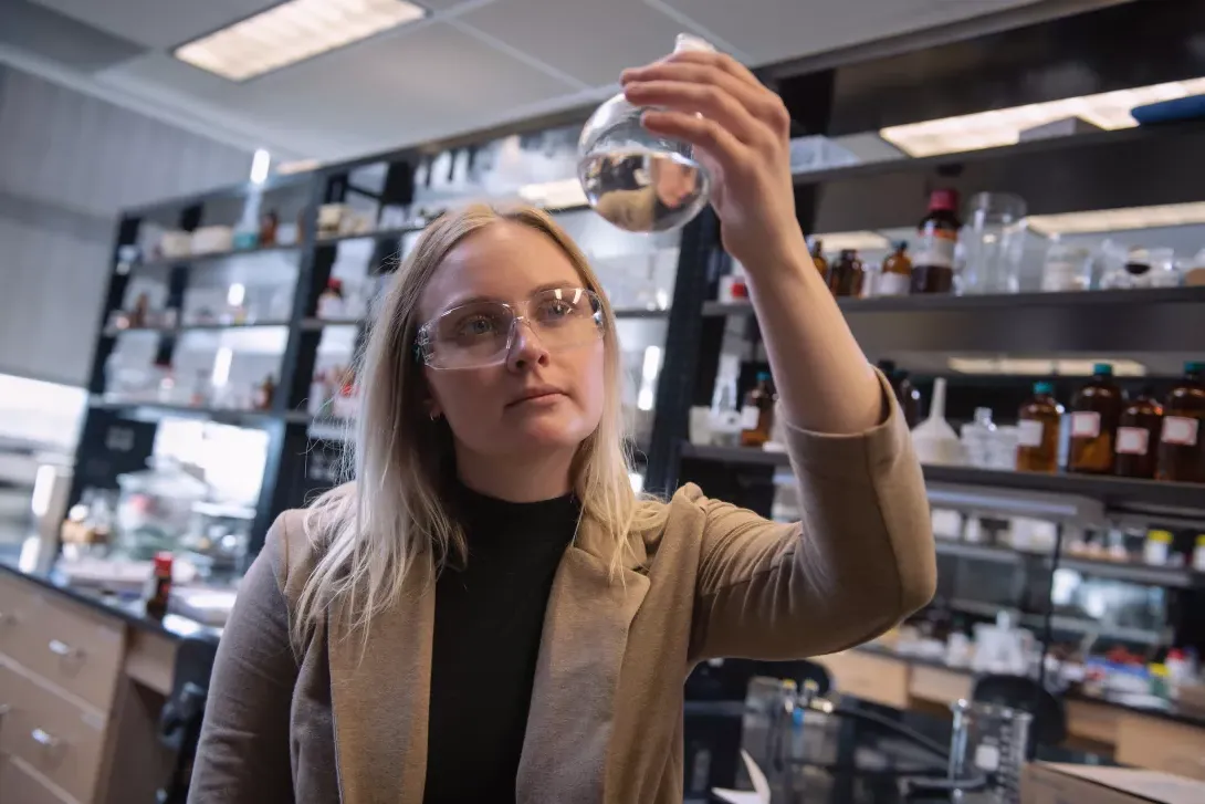 Student examining chemical flask in chemistry lab